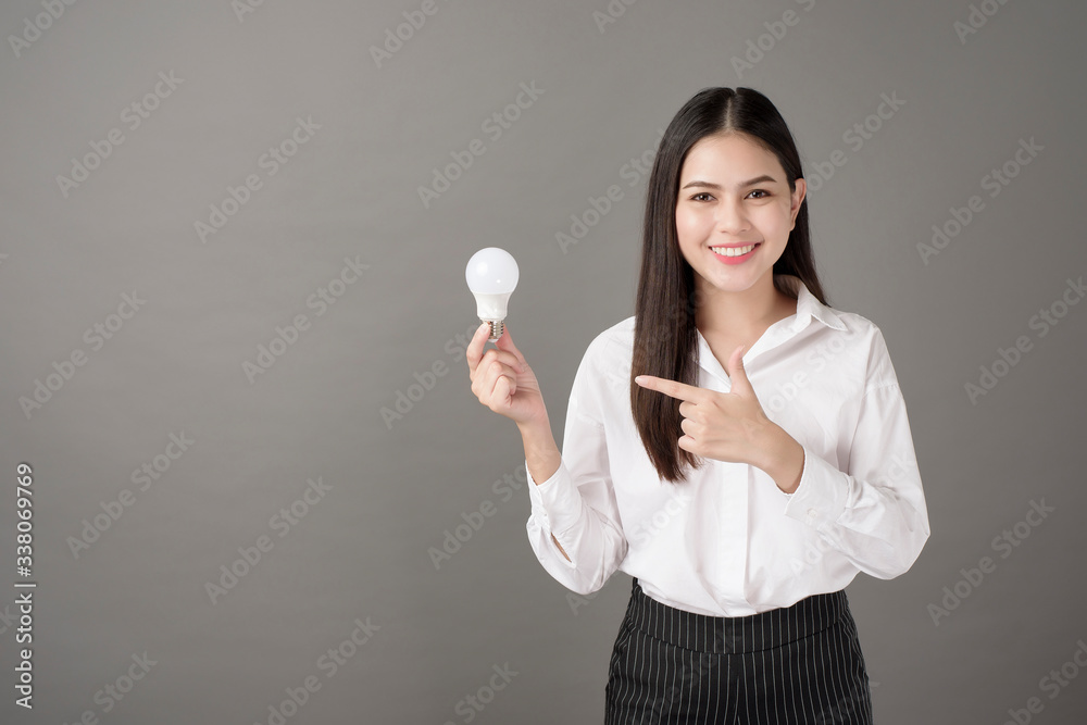 Beautiful intelligent woman is holding light bulb in studio Beautiful intelligent woman is holding light bulb in studio