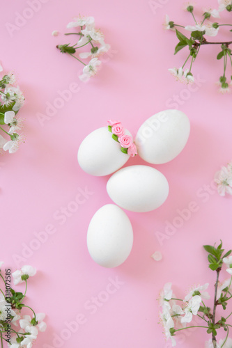 White eggs on pink background with flowers