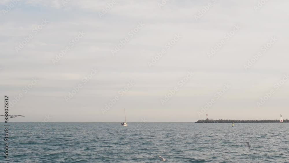 Beautiful sea view with a sailing yacht and seagulls. Beautiful sea view with a sailing yacht and seagulls.