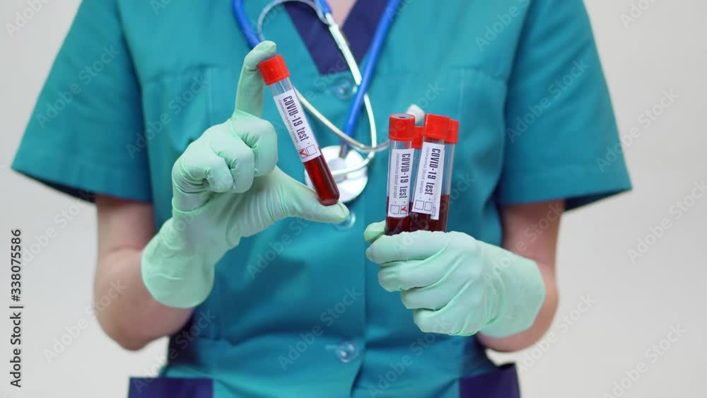 medical doctor nurse woman wearing protective mask and latex gloves - holding blood test tube