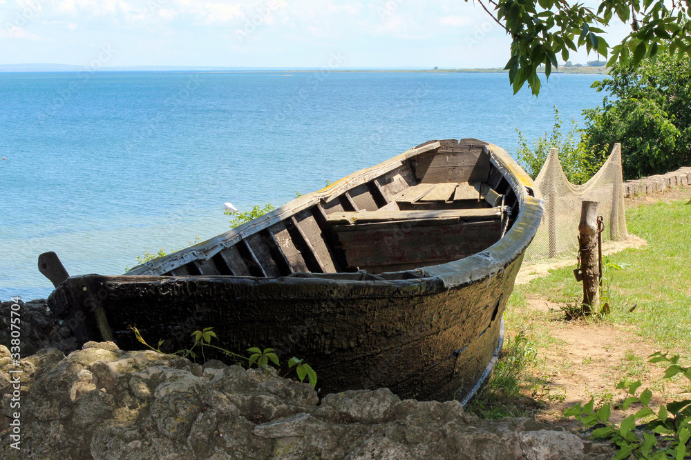 An old boat of a local fisherman stands on the shore on a nice Sunny day An old boat of a local fisherman stands on the shore on a nice Sunny day