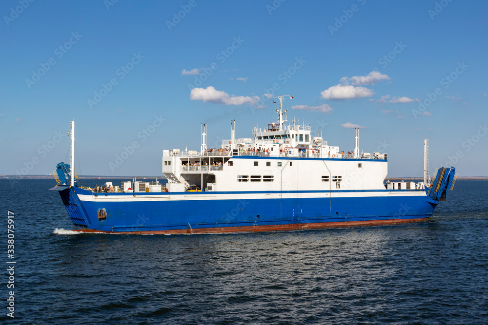 Ferry transports people and cars on a Sunny day