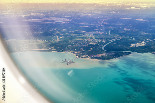 View from the side of the plane on the sea and the mainland of Malaysia. Avani Gold Coast Sepang top down view.