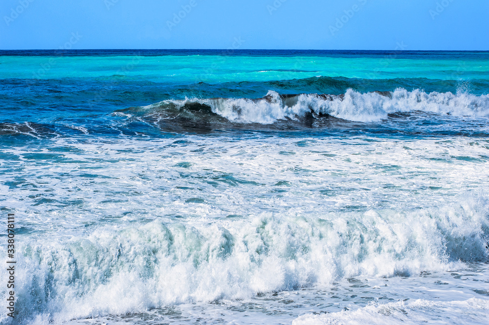 Fototapeta premium A fresh spring wind drives the waves to the coast of Cyprus. The Mediterranean Sea is painted with dark ultramarine and a luminous azure from the inside.