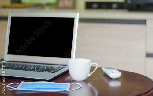 Sanitary masks and laptops on a wooden table, the idea of ​​working at home
