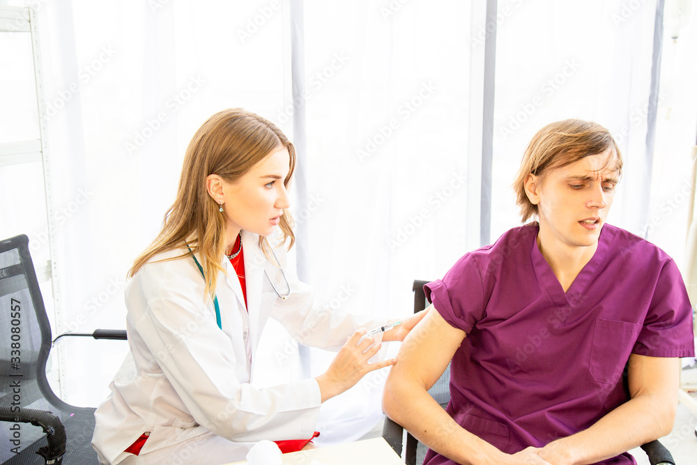 The female doctor to the syringe for injecting the patient in the examination room. The female doctor to the syringe for injecting the patient in the examination room.