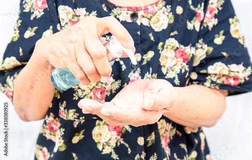 Elderly holding an alcohol gel for hand wash gel to prevent virus or covid19.