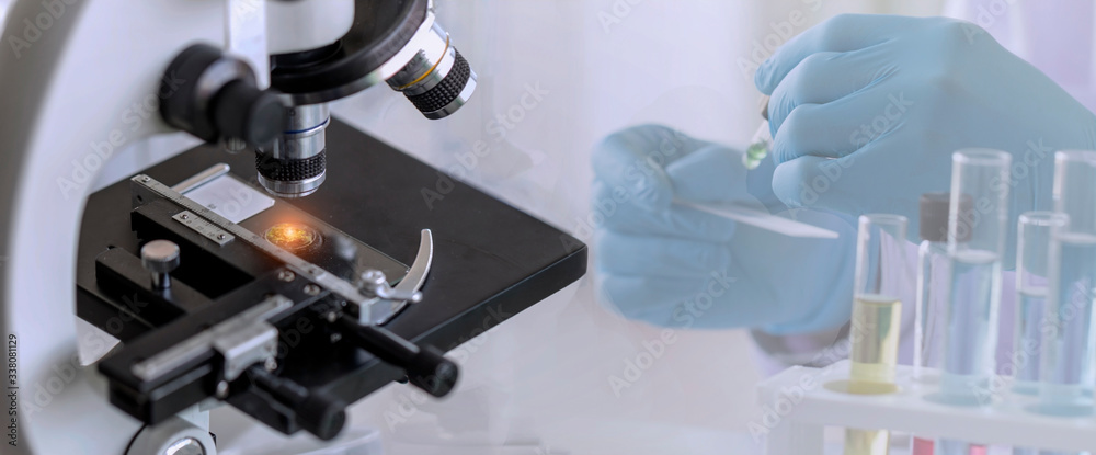 Close-up shot of microscope with a blurred picture of research in the laboratory Close-up shot of microscope with a blurred picture of research in the laboratory