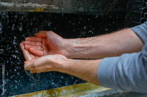A man washes his hands in purified water.