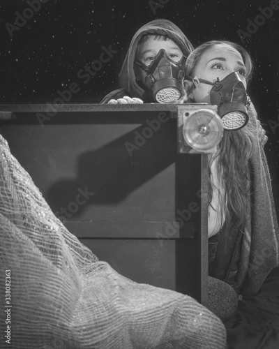 Mujer y un niño con mascaras antigás escenario post guerra - post apocalíptico