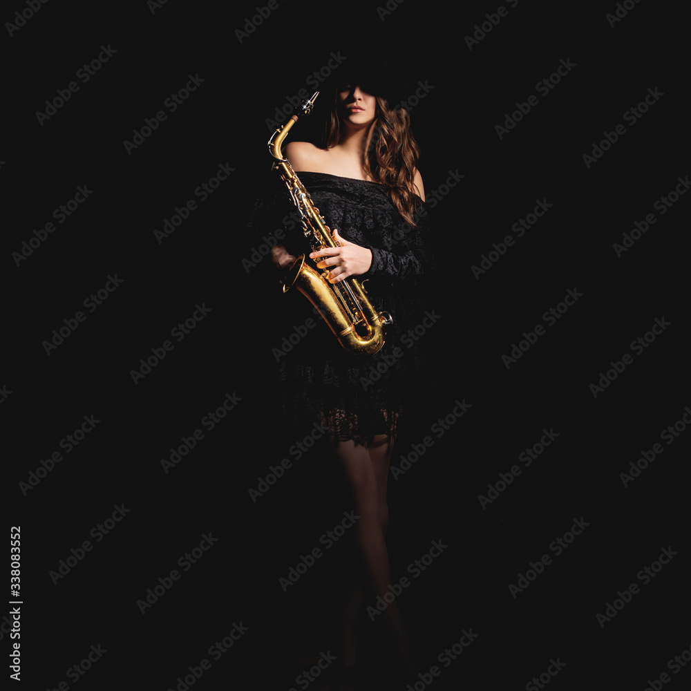 Obraz premium Saxophone player. Jazz musician saxophonist woman playing sax player isolated on black