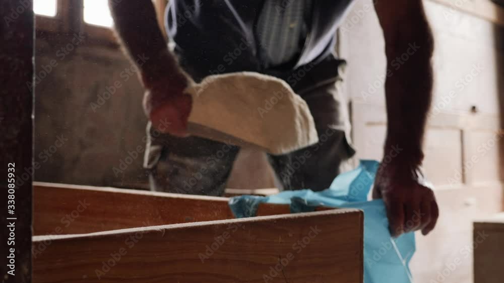 Old farm man taking corn flour from inside old food windmill / moulin