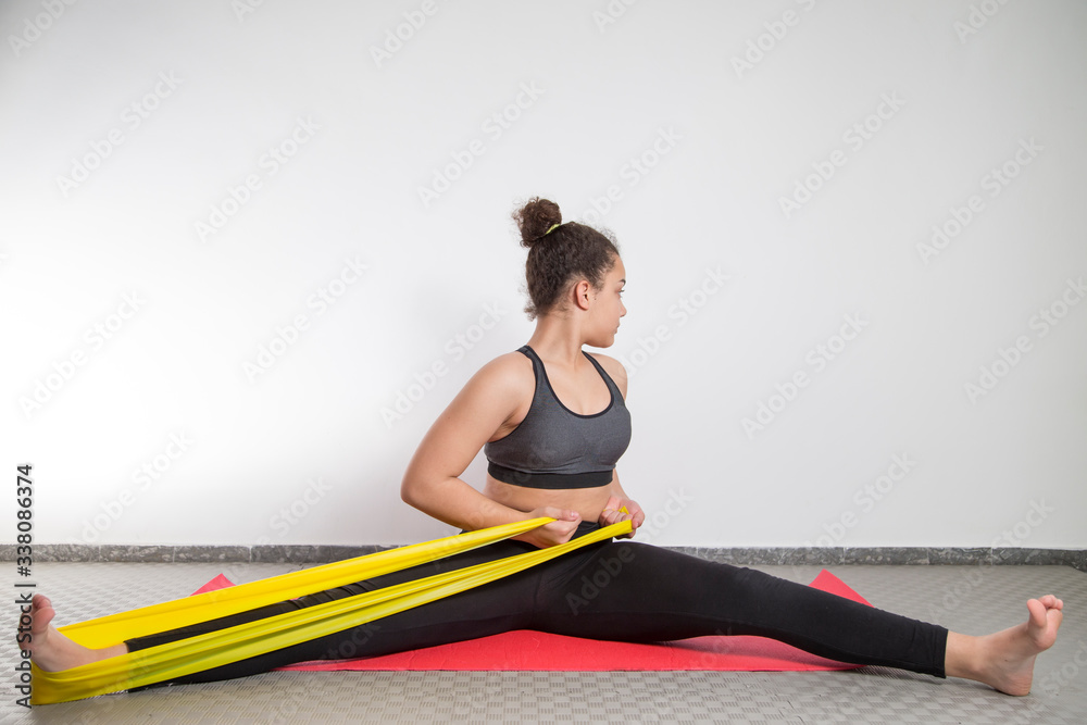 Girl training at home with rubber bands. Girl training at home with rubber bands.