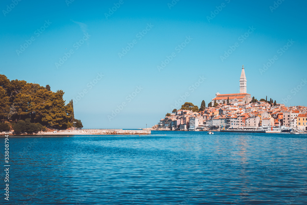 Panoramic view on Rovinj town, Croatian fishing port on the west coast of the Istrian peninsula. Colorful evening seascape of Adriatic Sea. Traveling concept background.