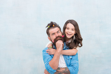 daughter and father with funny hairdo. hairdresser and barbershop. happy family day. small girl hugging her dad. bearded man father having fun with kid. childrens day. love and trust