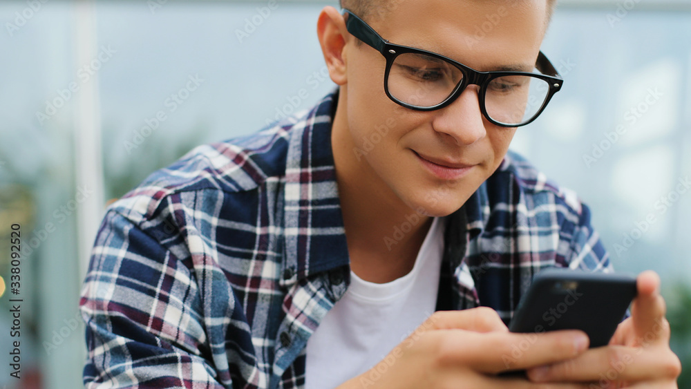 Happy smiling young man using modern smartphone device Happy smiling young man using modern smartphone device