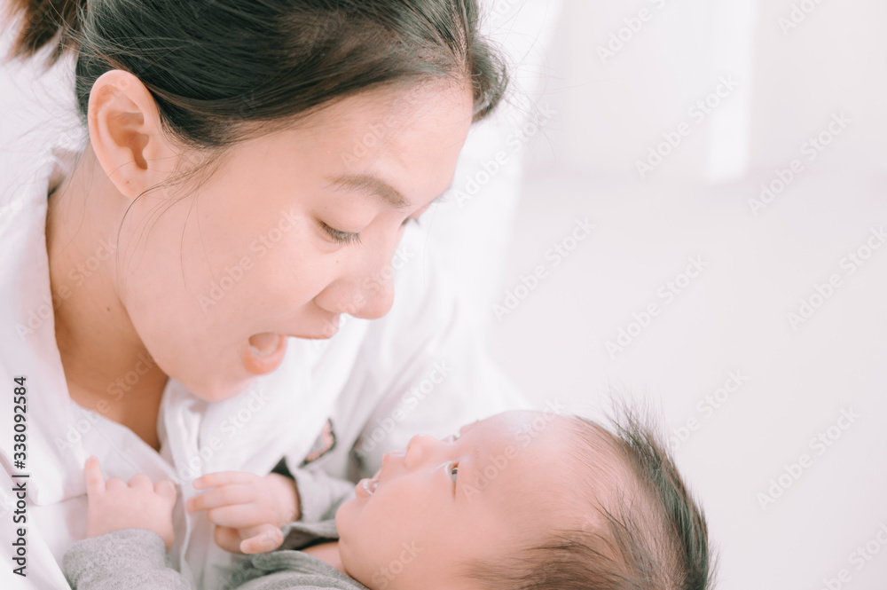 Asian woman holding a newborn baby in her arms at home.Mother day and newborn baby infant health care concept. Asian woman holding a newborn baby in her arms at home.Mother day and newborn baby infant health care concept.