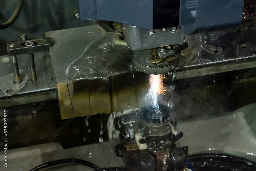 The wireEDM machine cutting the die parts with the sparking light. The