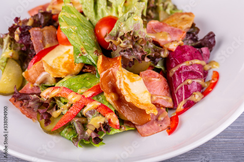 Salad with bacon, pickles, cherry tomatoes, sweet pepper and mustard sauce