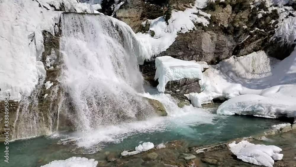 Slow motion Wapta Waterfall in Canada flowing down rocky cliff side. Slow mo waterfall into green river at waterfall base Slow motion Wapta Waterfall in Canada flowing down rocky cliff side. Slow mo waterfall into green river at waterfall base