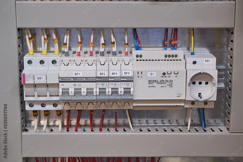 Fuse holder, two circuit breakers, power supply and socket in the electrical Cabinet. The wires and cables are connected to the electrical equipment and laid in the cable channel.