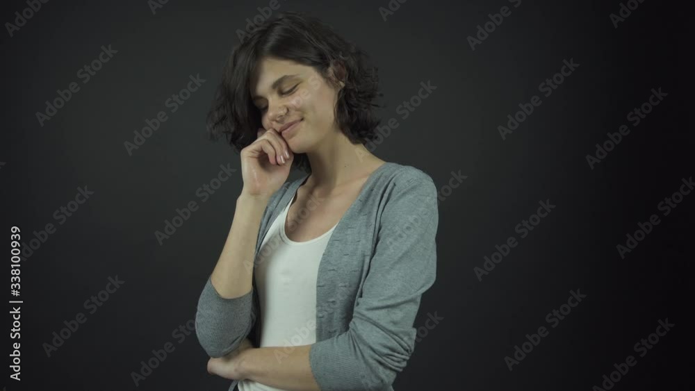 young woman in white top under grey jumper poses with smile young woman in white top under grey jumper poses with smile