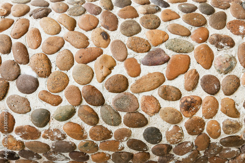 Texture background-a wall made of round old stone. yellow brown color.