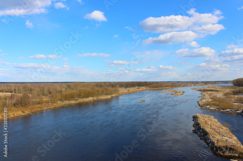 Fototapeta Naklejka Na Ścianę i Meble -  Beautiful landscape of nature from a height with a full-flowing river in the center, banks and a blue sky.
