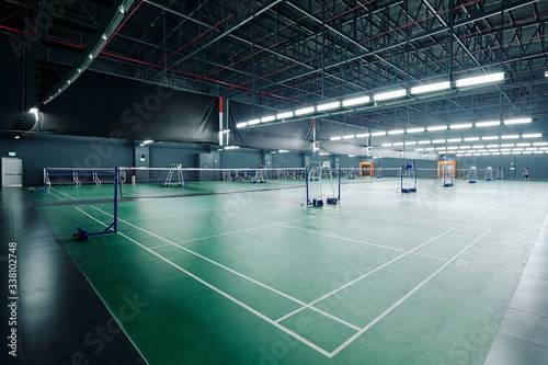 Big empty gymnasium with courts for playing tennis and badminton in health club
