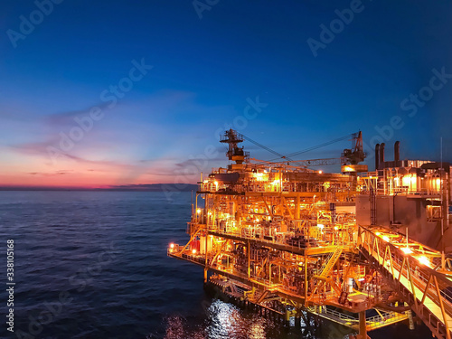 Offshore construction platform for exploration and production oil and gas with bridge in evening time for power energy of the world concept