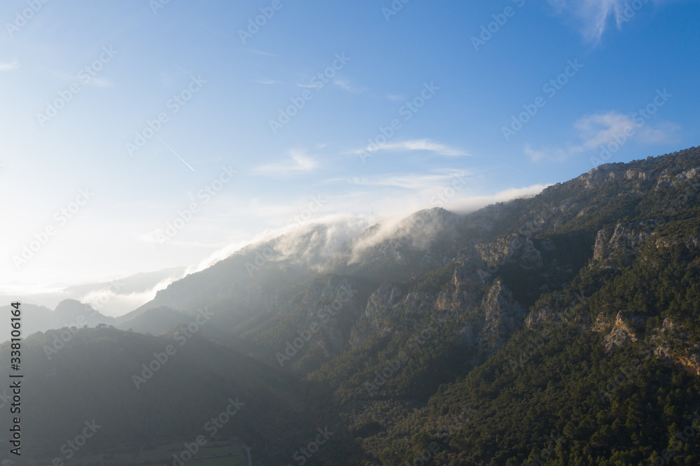 Drone shot of cloud coming from behind the moutain in Orient/Mallorca Drone shot of cloud coming from behind the moutain in Orient/Mallorca