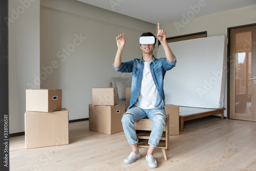 A young asian man is using VR glasses © 浩然 张