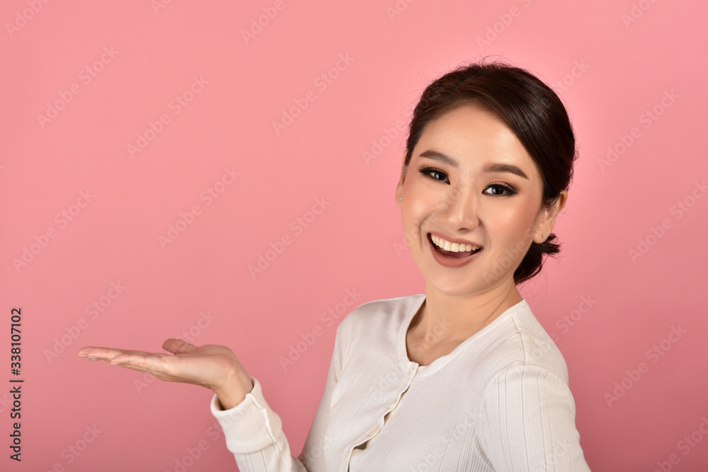 Beautiful asian woman hand open presenting product for mock-up advertising on pink background, Portrait of happy smiling girl with copy space. Beautiful asian woman hand open presenting product for mock-up advertising on pink background, Portrait of happy smiling girl with copy space.