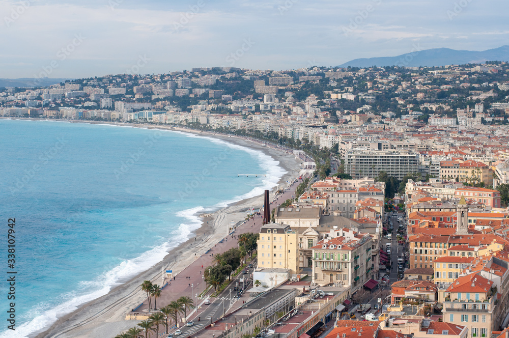 Fototapeta premium Luxury resort of French riviera. Beautiful panorama city of Nice in France. Sunny, summer day. Mediterranean sea, public beach, famous quay, palms and houses of Nice.