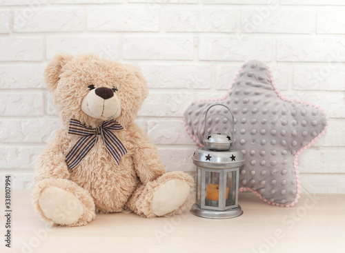 teddy bear on table in child room with pillow star and lantern