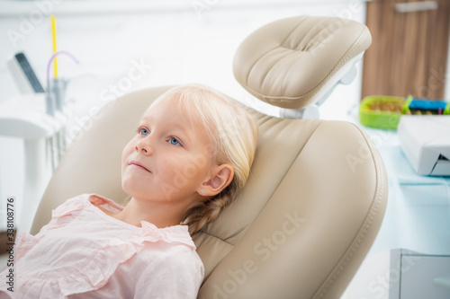 A little girl sitting in the dentistry office