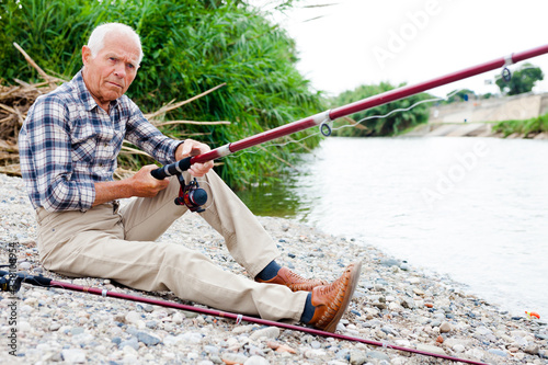 Aged man fishing at lakeside