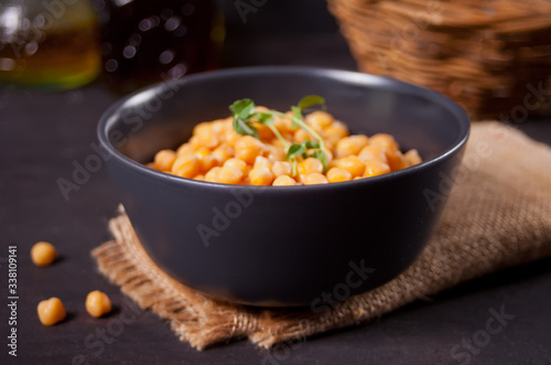 Cooked chickpeas in black bowl. Healthy and vegetarian food.