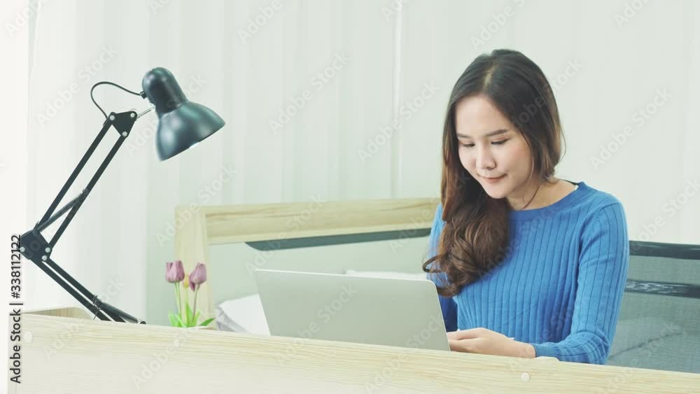 Asian young woman work from home and typing email on laptop. Girl sitting and using computer for working and chatting with custom. Working Study or shopping online at home.