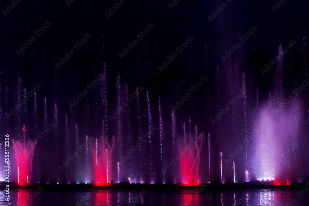 High evening fountain. Colored fountain against the background of the night sky.