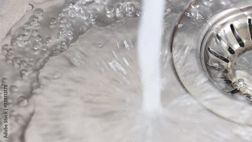 Water flows from a faucet to the sink. Opening and closing the tap. In slow motion. Water flows from a faucet to the sink. Opening and closing the tap. In slow motion.