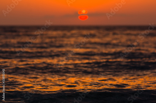 Amazing sea sunset on the pebble beach  the sun  waves  clouds