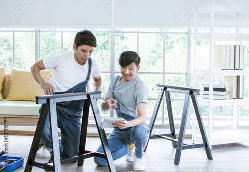 Two men are making furniture assembly
