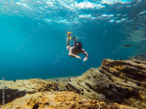 Underwater photo of men diver snorkeling in the sea water