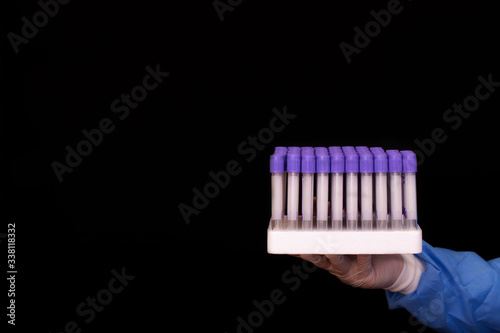 Wallpaper Mural A doctor holds in his hand the stand with empty glass test tubes for testing coronavirus patients. Medical blood test tubes isolated on black background Torontodigital.ca