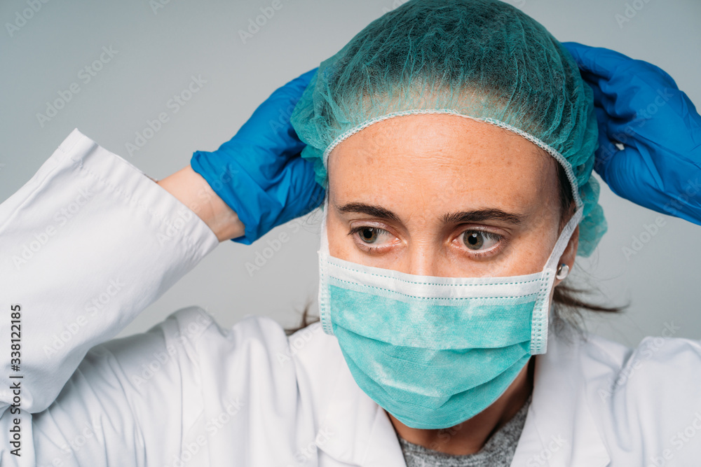 COVID-19 The coronavirus pandemic, woman doctor putting on medical mask, latex gloves and protective clothing against the virus COVID-19 The coronavirus pandemic, woman doctor putting on medical mask, latex gloves and protective clothing against the virus