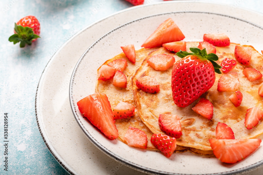 Pancakes with fresh strawberry on a blue wooden background Pancakes with fresh strawberry on a blue wooden background
