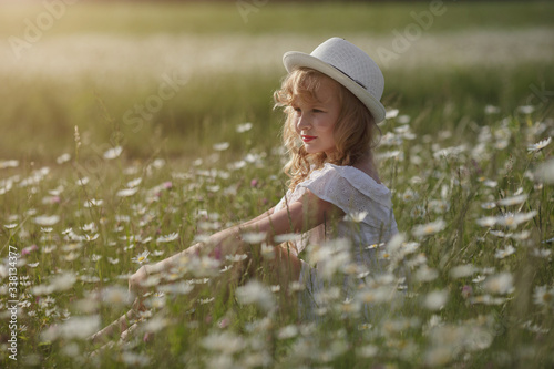 Fototapeta Naklejka Na Ścianę i Meble -  beautiful blonde teen girl in a field of daisies