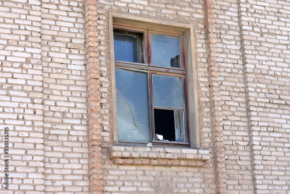 broken window in the brick wall of an old building.