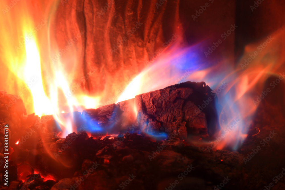 Płomienie z palącego się drewna w kominku w kolorze złotym, czerwonym i niebieskim. - obrazy, fototapety, plakaty 